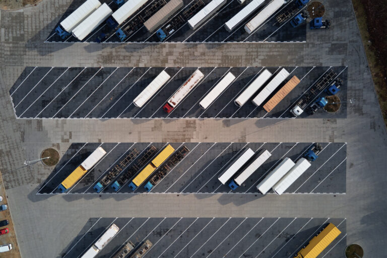 Top view of trucks on parking lot near logistic warehouse